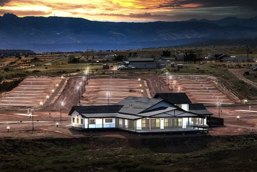 Observer Ranch Campground at sunset with modern visitor center building and organized RV sites with electrical hookups across mountain valley landscape