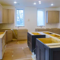 A kitchen with finished cabinets is undergoing construction