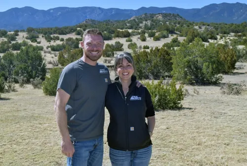 Derek and Lesley True, founders of True North Construction Company, standing together against a backdrop of beautiful Colorado mountain scenery.